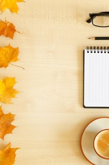 Desktop with notebook, pencil, eyeglasses and coffee cup.