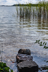 Fototapeta na wymiar Stone on the water by the lake