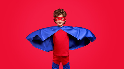 Little superhero in blue cape