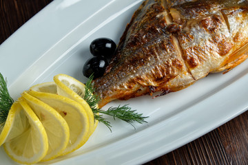 Grilled fish with a side dish and vegetables. restaurant menu