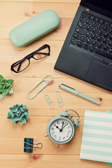 Top view over working place with laptop and office supplies
