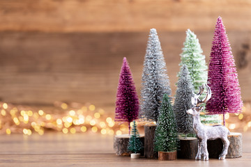 Colorful Christmas tree on wooden, bokeh background.