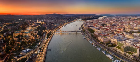 Photo sur Plexiglas Széchenyi lánchíd Budapest, Hungary - Aerial panoramic view of Budapest with Szechenyi Chain Bridge, Buda Castle Royal Palace and St.Stephen's Basilica. Time blending: Pest side is at daylight, Buda side is at dusk.