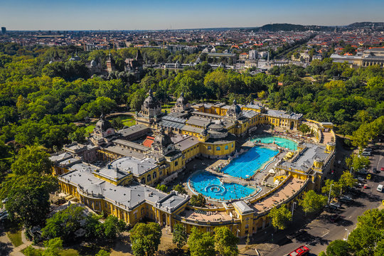 Budapest, Hungary - Aerial drone view of the famous Szechenyi Thermal Bath and Spa on a sunny summer day. Heroes' Square and Vajdahunyad Castle at background.