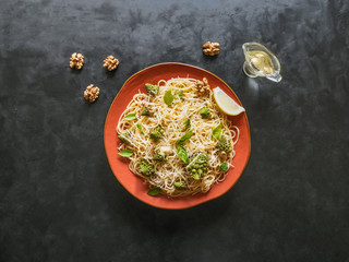 Pasta with romanesco cauliflower (broccoli) on a black table.