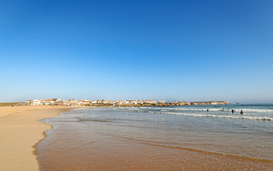View to Surfer beach Praia do Lagido and island Baleal with fishing village in summer, Peniche Portugal