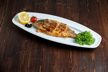 Grilled fish with a side dish and vegetables. restaurant menu