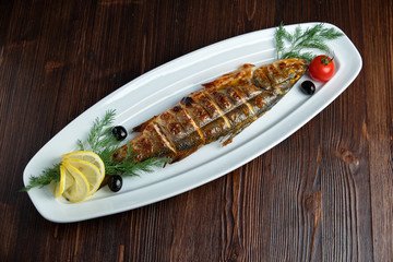 Grilled fish with a side dish and vegetables. restaurant menu