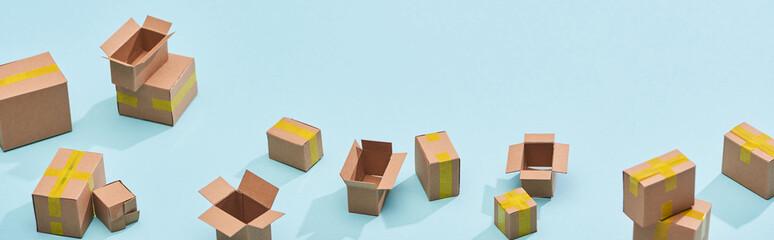 panoramic view of miniature postal boxes with yellow adhesive tape on blue background