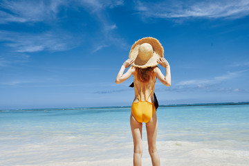 Fototapeta na wymiar woman in hat on the beach