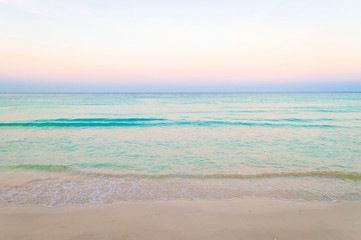 Fototapeta na wymiar Tropical sea background of pastel sunset skies glowing above tranquil turquoise blue horizon