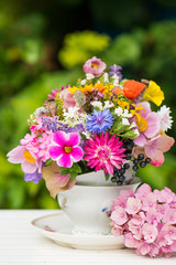 Colorful wild blossoms in a old coffee cup
