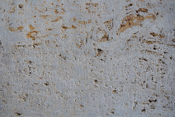 Rough white natural stone travertine with small random cavities. Limestone building material. 