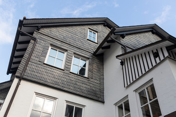 Architectural detail of typical half-timbered Vakwerk homes in the spa village of Grafschaft in the Sauerland region in Germany at sunset with clouds