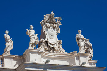 Fototapeta na wymiar Detail of the Chigi coats of arms and the statues of saints that crown the colonnades of St. Peter Square built on 1667 on the Vatican City