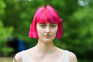 Pink Hair and Blue eyes beautiful young adult woman looking to camera 