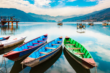 Colourful wooden tourist boats in Pokhara lake in Nepal.