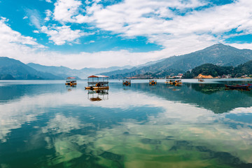 Naklejka premium Colourful wooden tourist boats in Pokhara lake in Nepal.