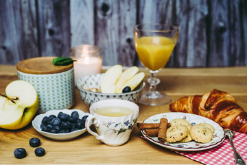 Petit déjeuner sain avec muesli pomme myrtilles croissant et biscuits cannelle