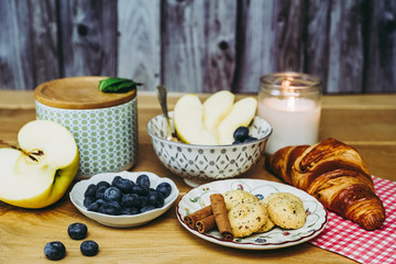 Petit déjeuner sain avec muesli pomme myrtilles croissant et biscuits cannelle