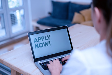 Conceptual hand writing showing Apply Now. Concept meaning request something officially in writing or by sending in form woman with laptop smartphone and office supplies technology