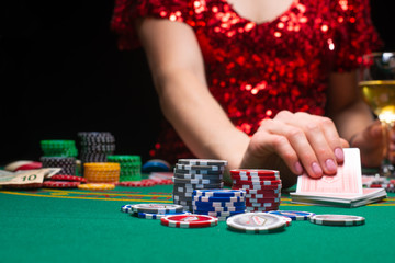 A girl in an evening red dress plays in a casino and draws cards. Gambling business casino