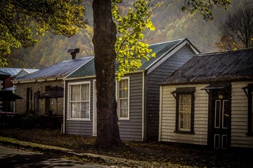 Fototapeta na wymiar Quaint homes under the fall foliage of Arrowtown, New Zealand