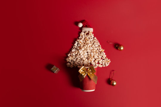 Christmas tree shaped popcorn on a red background. View from above. Flat layer