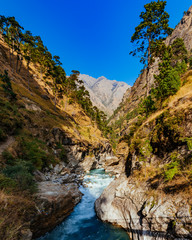 Fototapeta na wymiar River flows trough rocky valley in Himalaya mountains in Nepal.