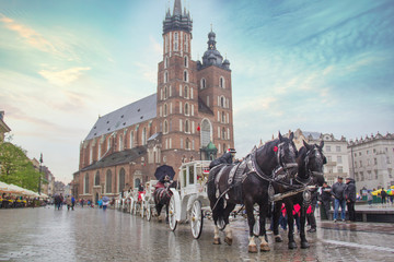 Naklejka na ściany i meble Krakow, Poland - MARCH 24: Excursion carriage near Church of the Assumption of the Blessed Virgin Mary (St. Mary's Church) on March 24, 2017, in Krakow