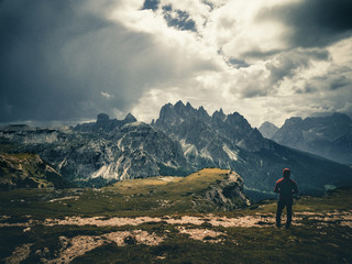 Fototapeta na wymiar young man enjoying the view of the mountains landscape in the dolomites mountain range.
