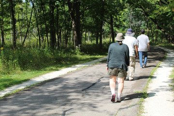 Three older people walking on the North Branch Trail at Miami Woods in Morton Grove