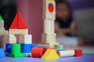 baby building a castle made of wooden blocks. children development process. blurred baby playing toy in a playpen.