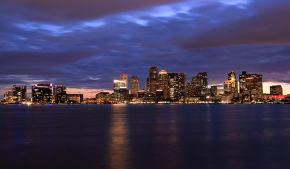 Fototapeta na wymiar Boston skyline at night, with skyscrapers reflection on the ocean, Massachusetts, USA