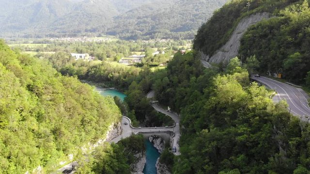 Aerial push in shot over the beautiful landscape around Kobarid with RIver Soča and Napoleon's Bridge