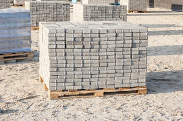Paving grey slabs fot pavement construction in city. Gray concrete paving slabs on sand bedding to level for laying granite paver blocks