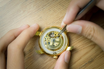 Watchmaker hands close mechanism repair With tools placed on the table