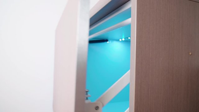 Cabinet door ascending mechanism close-up 4K. Side view handheld shot of door hinges in kitchen cabinet.