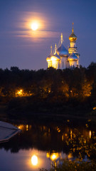 St. Sophia Cathedral and bell tower at night, against a full moon.