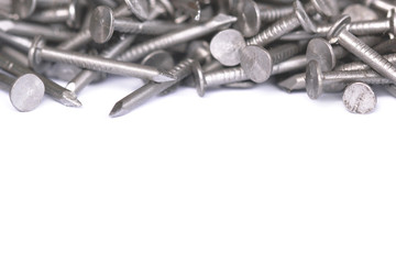 Steel nails laid out in the form of a frame with a place under the text. A pile of sharp nails on a white isolated background with copy space.
