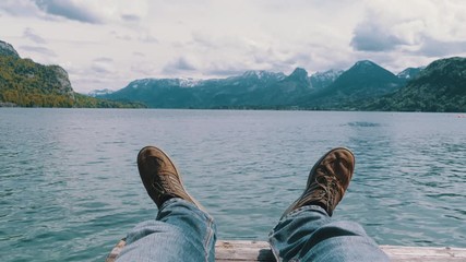 Human Legs on the Background of a Mountain Lake and Snow-covered Mountains.