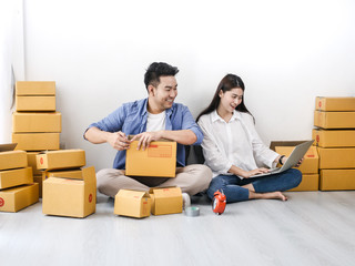 Asian couple with stack of parcel boxes, online business and delivery concept.