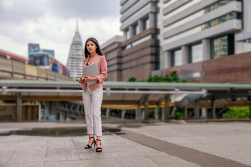 ayoung woman is walking on the street with train background