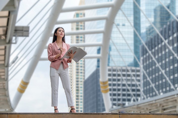 Fototapeta premium a business woman is standing and working in the city