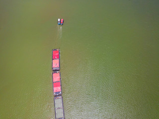The large cargo ship on the Chao Phraya Aerial view of the large cargo ship on the Chao Phraya River, The river with green water in rainy season, Copy space, Top view, Bangkok, Thailand.