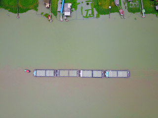 The large cargo ship on the Chao Phraya Aerial view of the large cargo ship on the Chao Phraya River, The river with green water in rainy season, Copy space, Top view, Bangkok, Thailand.