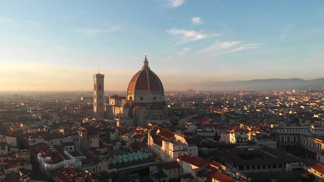 In Florence Italy, the drone pans right and moves left as it highlights the Duomo on a gorgeous sunset.