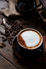 Cup of coffee latte and coffee beans with coffee dripper set on wood table.