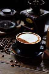 Cup of coffee latte and coffee beans with coffee dripper set on wood table.