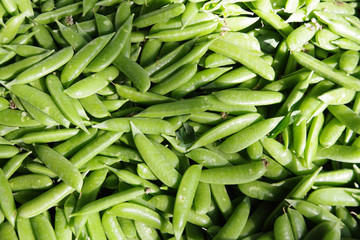 Close-up full frame view of a large box full of organic snap peas displayed at a farmers market stand